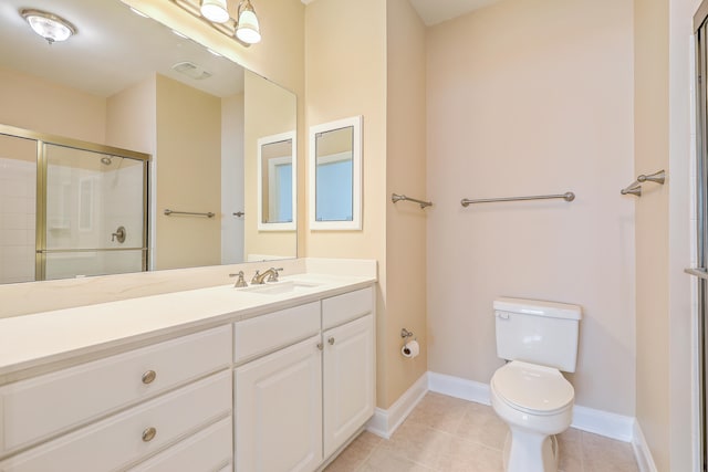 bathroom with toilet, vanity, and tile patterned floors