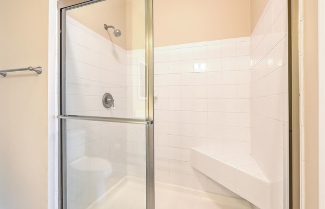 bathroom with toilet and an enclosed shower