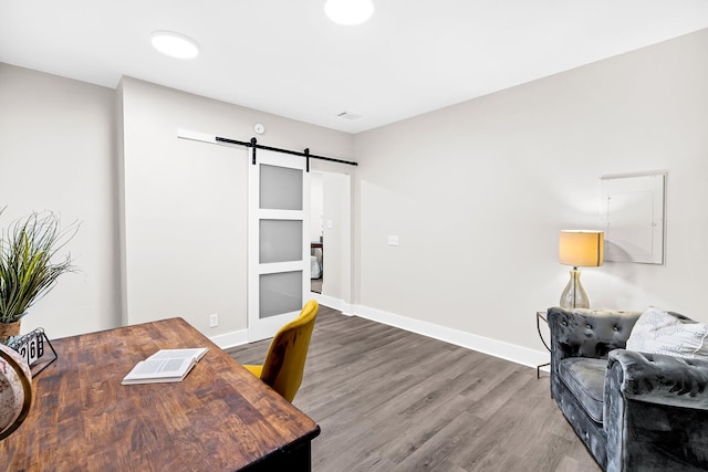 office featuring a barn door and hardwood / wood-style floors