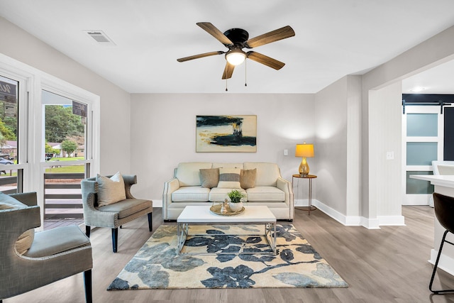 living room featuring light hardwood / wood-style floors and ceiling fan