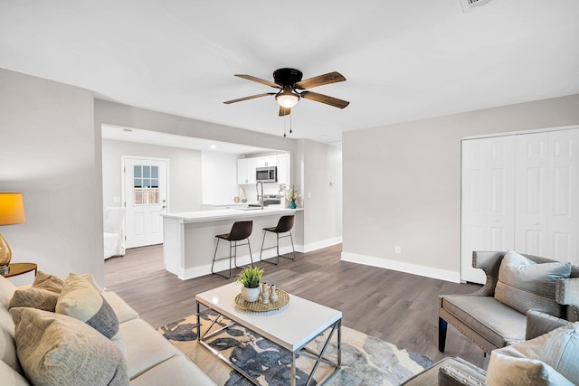 living room with hardwood / wood-style floors and ceiling fan