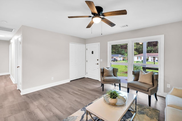 living room with ceiling fan and light hardwood / wood-style flooring