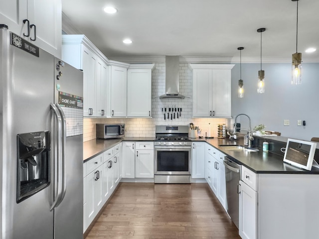 4 Line St, Charleston, SC 29403 - kitchen featuring appliances with stainless steel finishes, wall chimney exhaust hood, a peninsula, dark countertops, and dark wood-style flooring