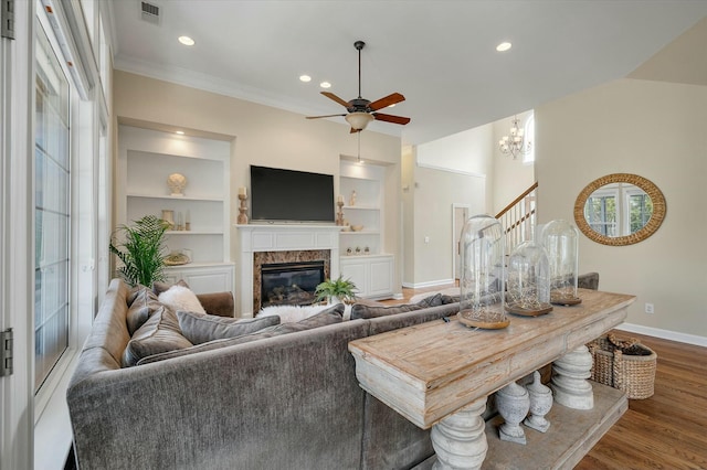 living area with baseboards, visible vents, built in features, stairway, and wood finished floors