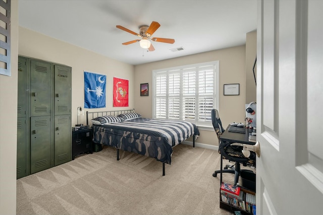 bedroom featuring light carpet, baseboards, visible vents, and a ceiling fan