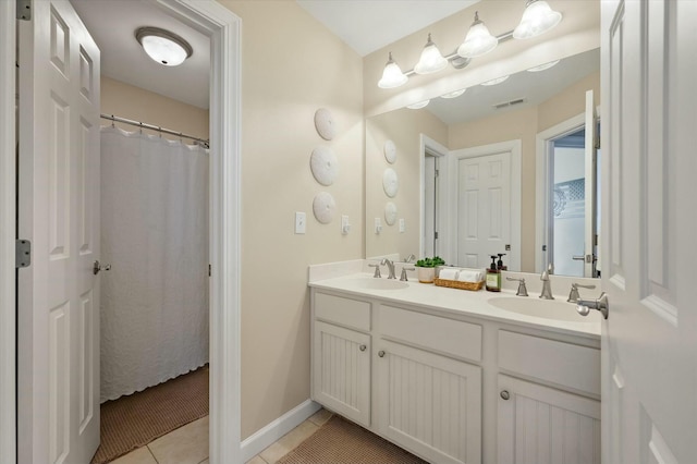 bathroom featuring double vanity, visible vents, a sink, and tile patterned floors