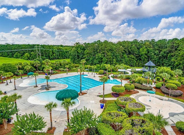 community pool with a patio area and a water slide