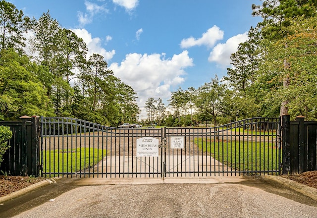 view of gate featuring a yard and fence