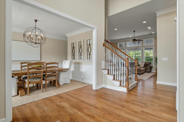 dining room featuring stairway, light wood-type flooring, and crown molding