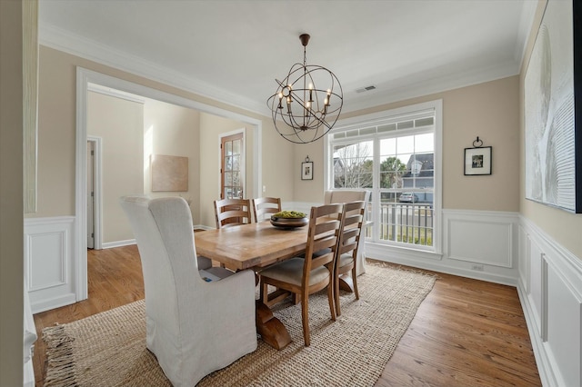 dining room with ornamental molding, a chandelier, and light wood finished floors