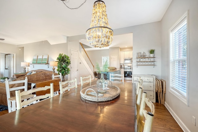 dining area with hardwood / wood-style flooring and a notable chandelier