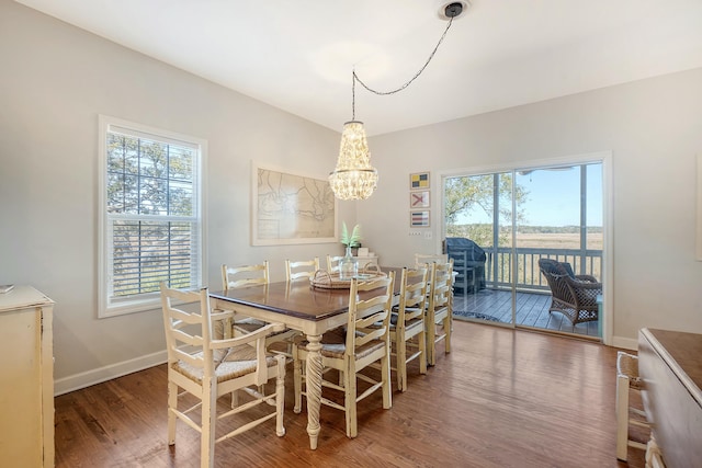 dining room with dark hardwood / wood-style flooring, plenty of natural light, and a chandelier