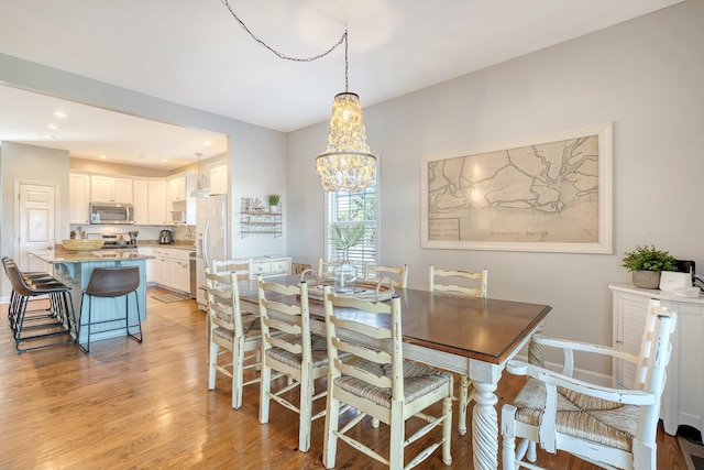 dining room with an inviting chandelier and light wood-type flooring