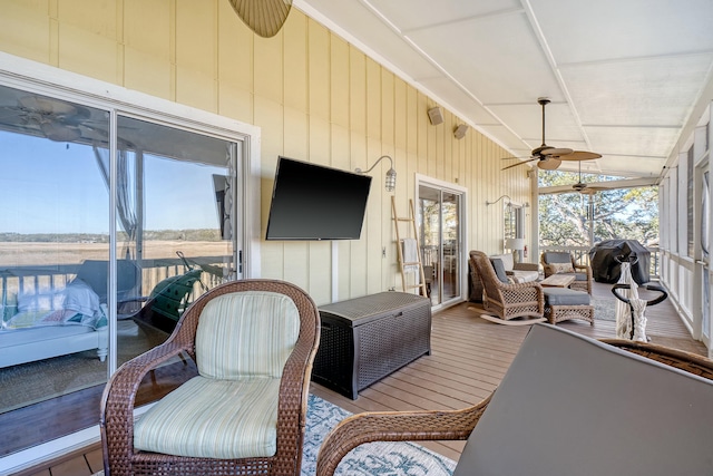 sunroom with ceiling fan and vaulted ceiling