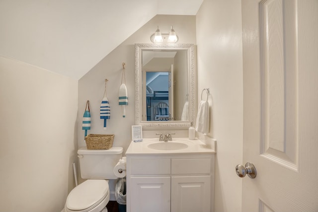 bathroom with vanity, vaulted ceiling, and toilet