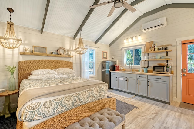 bedroom with multiple windows, an AC wall unit, sink, and light hardwood / wood-style flooring