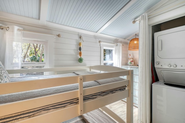 laundry area with stacked washer and dryer and a healthy amount of sunlight