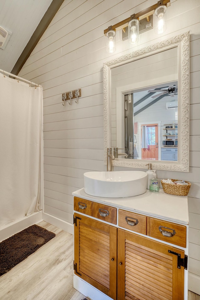 bathroom featuring walk in shower, vanity, vaulted ceiling, and hardwood / wood-style floors