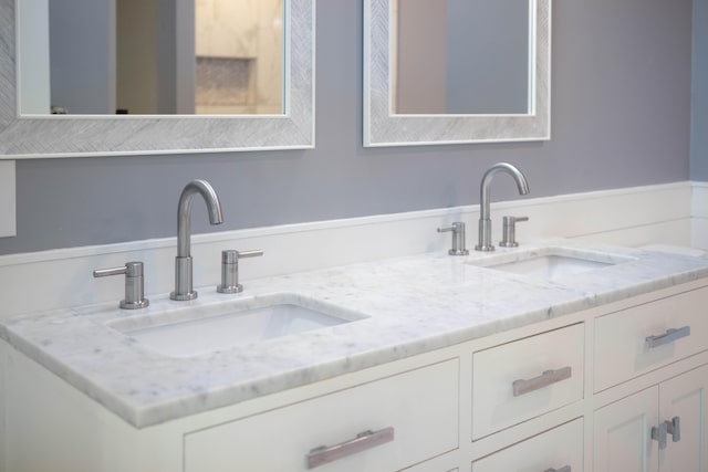 bathroom featuring a sink and double vanity