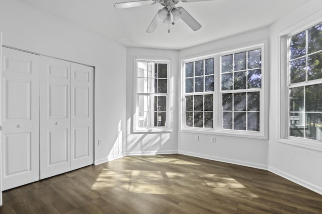 unfurnished bedroom featuring dark wood-style floors, ceiling fan, a closet, and baseboards