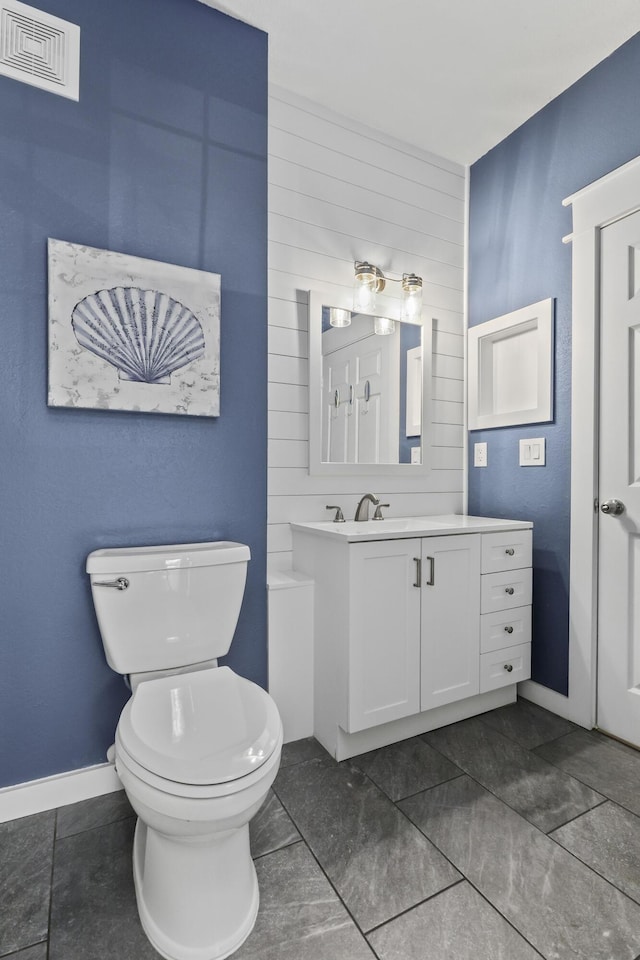 bathroom featuring baseboards, visible vents, vanity, and toilet