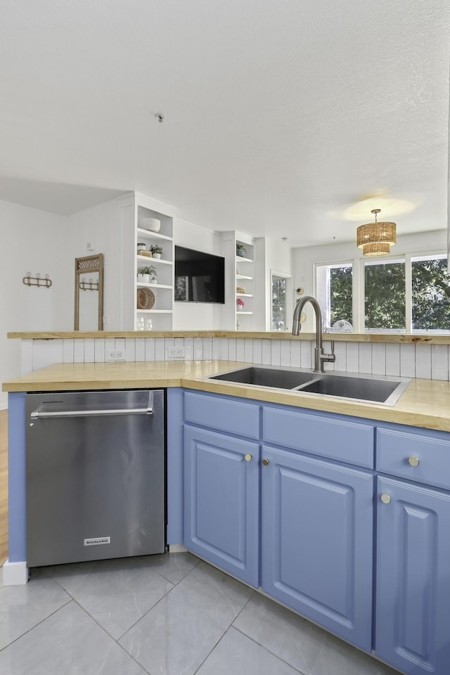 kitchen featuring light countertops, stainless steel dishwasher, a sink, a textured ceiling, and blue cabinets