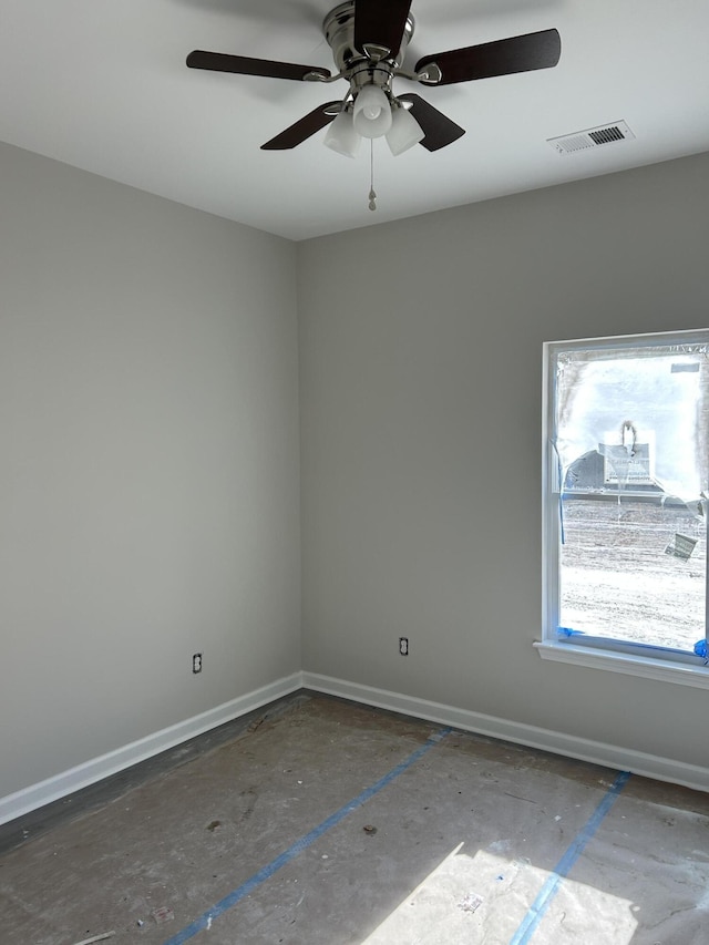 empty room featuring a ceiling fan, visible vents, and baseboards