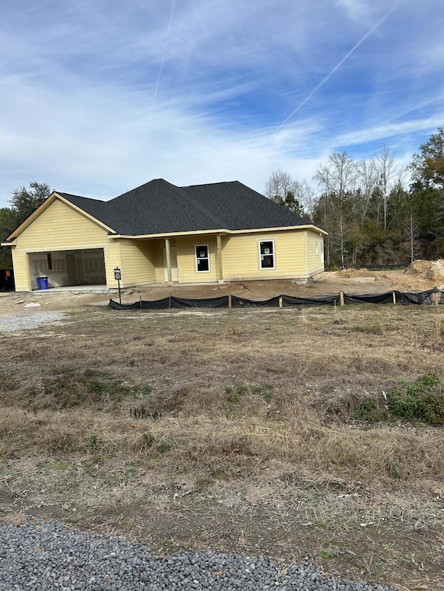 view of front facade featuring a shingled roof and an attached garage