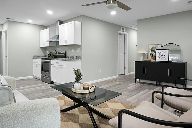 living room with ceiling fan and light hardwood / wood-style flooring