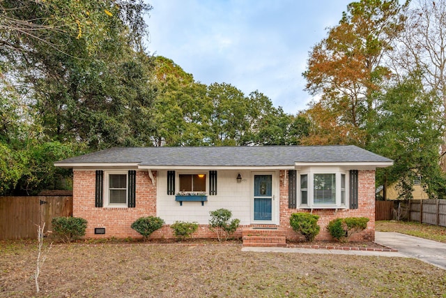 ranch-style house featuring crawl space, a shingled roof, fence, and brick siding