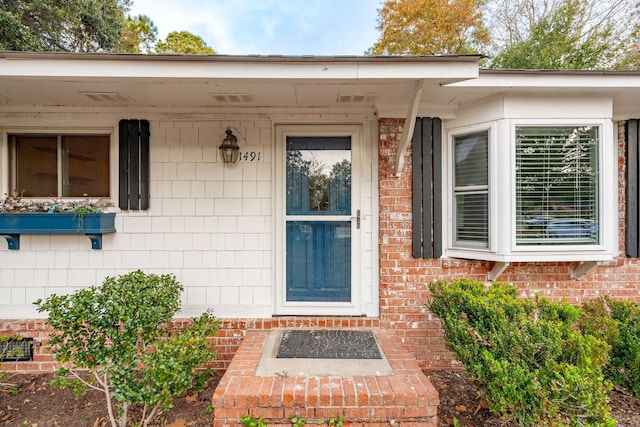 property entrance featuring brick siding