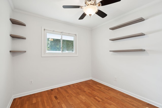 unfurnished room featuring baseboards, ceiling fan, wood finished floors, and crown molding