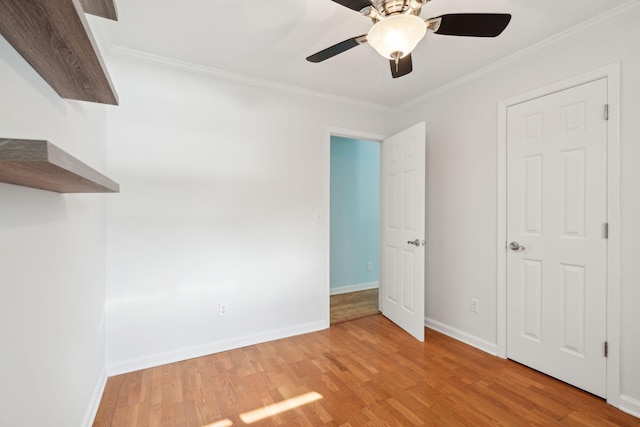 unfurnished bedroom with light wood-style flooring, baseboards, and crown molding