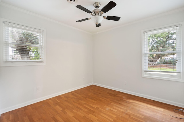 empty room with light wood finished floors, ceiling fan, ornamental molding, and baseboards