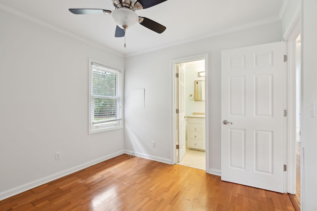 unfurnished bedroom featuring crown molding, light wood finished floors, ceiling fan, ensuite bath, and baseboards