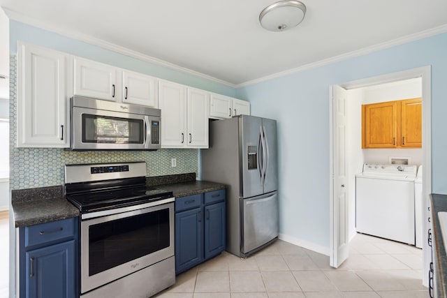 kitchen with blue cabinets, washer / dryer, appliances with stainless steel finishes, and white cabinets