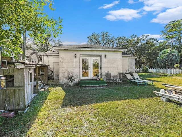 back of property featuring a yard and french doors