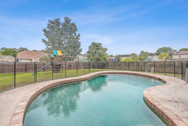 view of swimming pool with a playground and a yard