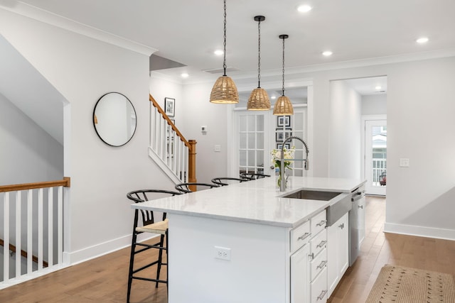 411 Katies Scenic Ct, Wando, SC 29492 - kitchen with light wood-style floors, ornamental molding, a center island with sink, white cabinetry, and dishwasher