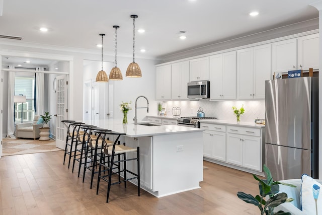 411 Katies Scenic Ct, Wando, SC 29492 - kitchen with stainless steel appliances, a sink, decorative backsplash, crown molding, and a kitchen island with sink
