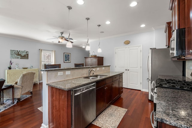 kitchen with dark wood-type flooring, an island with sink, a sink, appliances with stainless steel finishes, and crown molding