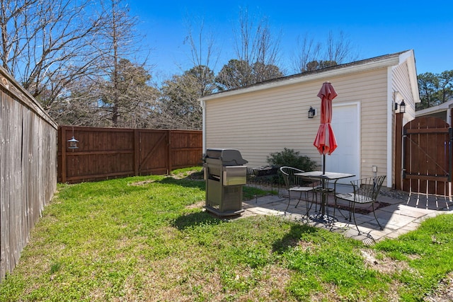 view of yard with a patio area, an outdoor structure, a fenced backyard, and a gate