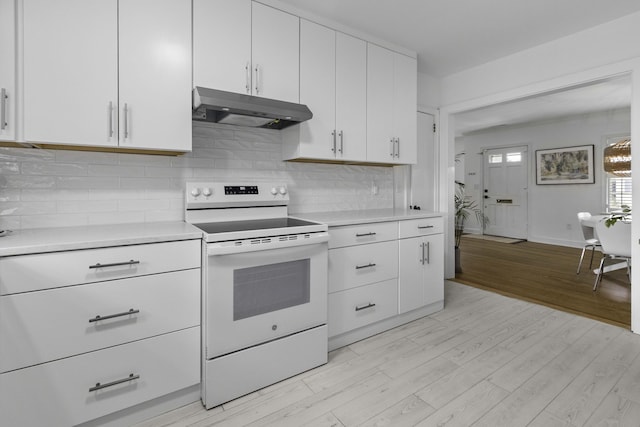 kitchen featuring white range with electric cooktop, light countertops, under cabinet range hood, light wood-type flooring, and backsplash