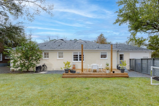 back of house featuring brick siding, a lawn, fence, and a wooden deck