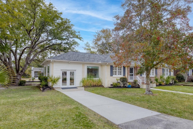 view of front of property with french doors, a front yard, and a shingled roof