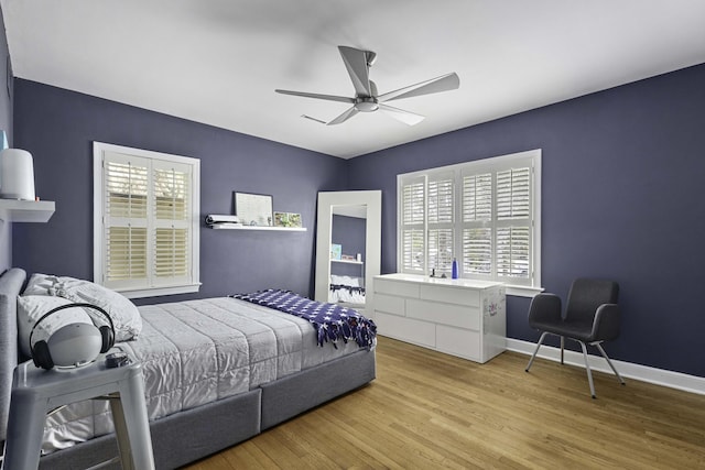 bedroom with baseboards, wood finished floors, and a ceiling fan