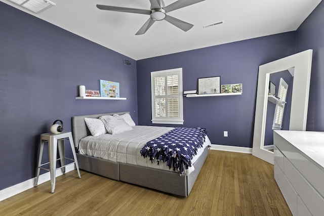 bedroom featuring wood finished floors, visible vents, and baseboards