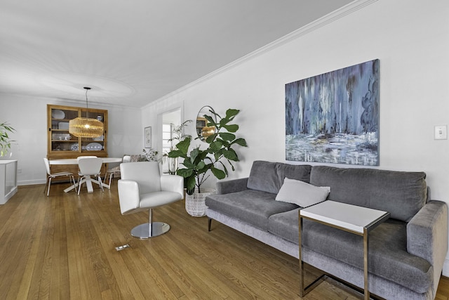 living area featuring wood finished floors and ornamental molding