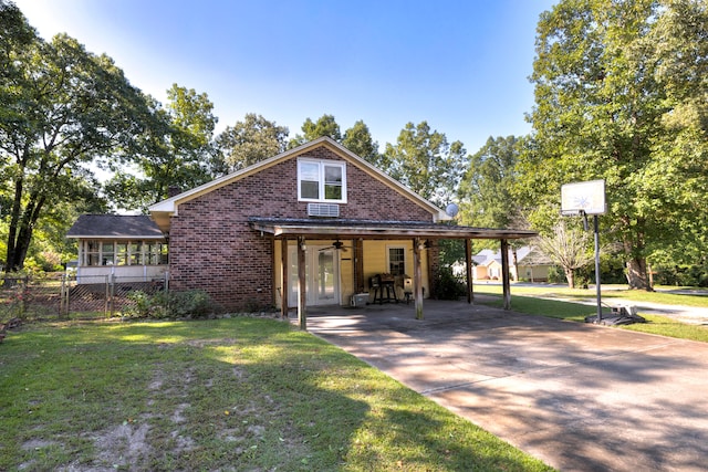 view of front of property with ceiling fan, a front yard, and a carport