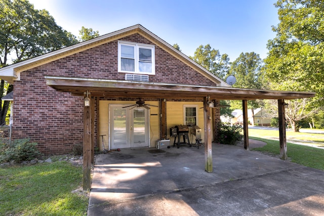 view of front facade with french doors, ceiling fan, a front yard, and a carport